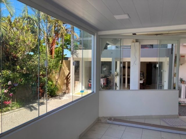 Varanda envidraçada com vista para o jardim
